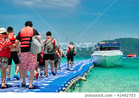 Tourists go by the boat at the pier plastic. Tourists go by the boat at the pier plastic. 41492783