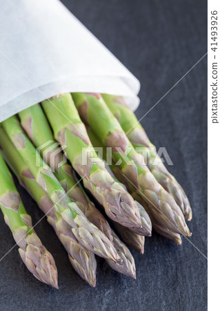 Bunch of fresh green asparagus on a dark slate Bunch of fresh green asparagus on a dark slate 41493926