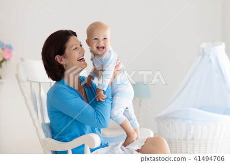 Mother and baby at home. Mom and child in bedroom. 41494706