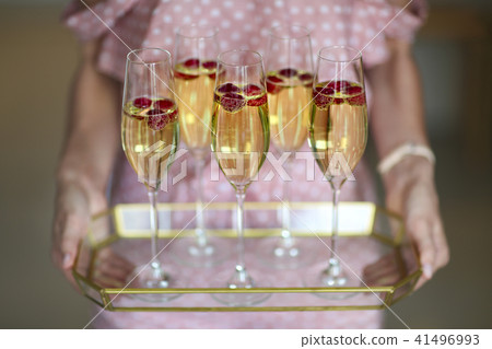 Young woman with champagne glasses on tray 41496993
