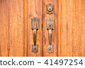 Vintage brass door handle with lock on wooden door 41497254