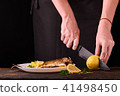 Unrecognizable woman cutting fresh lemon 41498450