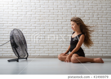 the girl is sitting in front of the fan the girl is sitting in front of the fan 41498979