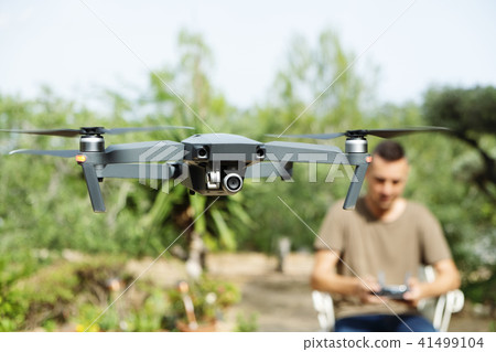 man operating a drone in a natural landscape. 41499104