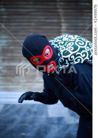 One man (Residential invasion thief crime criminal illegal culprit villain stolen cigarette hat disguised suspect case criminal) 41499976