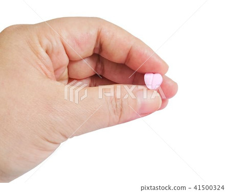 Hand Holding Pink Heart of Vitamins on White 41500324