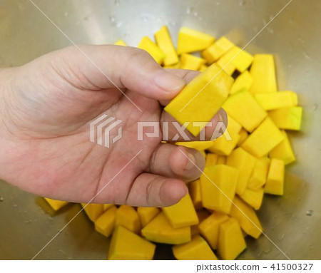 Hand Holding Fresh Pumpkin From The Bowl 41500327