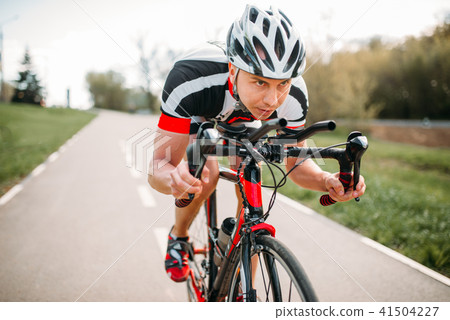 Male cyclist rides on bicycle, front view Male cyclist rides on bicycle, front view 41504227