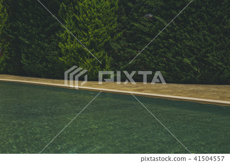 blue water in the pool on the background of a wooden floor with green tree 41504557