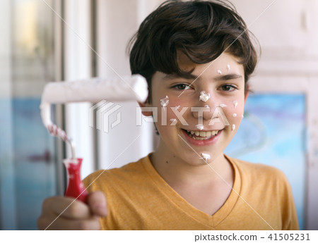 smiling teenager boy with white paint roller and dirty face make repaint smiling teenager boy with white paint roller and dirty face make repaint 41505231