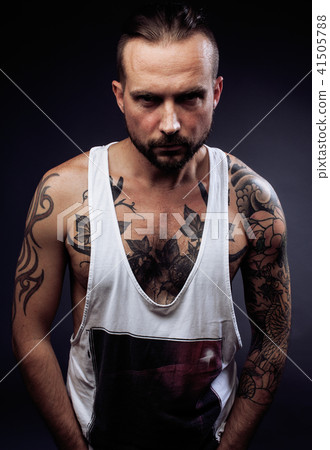 A man with tattooes on his arms. Silhouette of muscular body. ca A man with tattooes on his arms. Silhouette of muscular body. ca 41505788