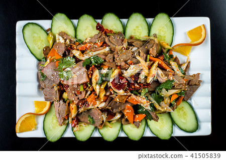 Chinese cuisine, boiled beef with cucumber and tomato in white plate, on black background Chinese cuisine, boiled beef with cucumber and tomato in white plate, on black background 41505839
