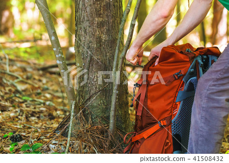 Hiker holding his camping backpack Hiker holding his camping backpack 41508432