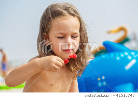 Beautiful boy is eating raspberries 41513745