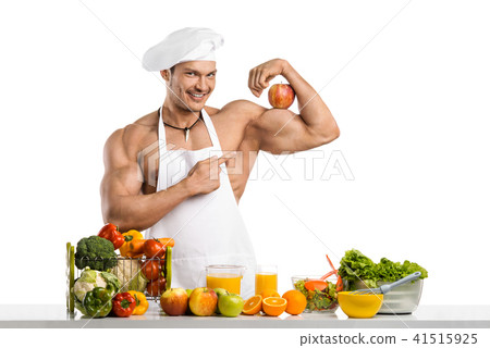 Man bodybuilder cook with apple on biceps Man bodybuilder cook with apple on biceps 41515925