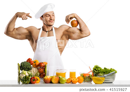 Man bodybuilder cook with apple on biceps Man bodybuilder cook with apple on biceps 41515927