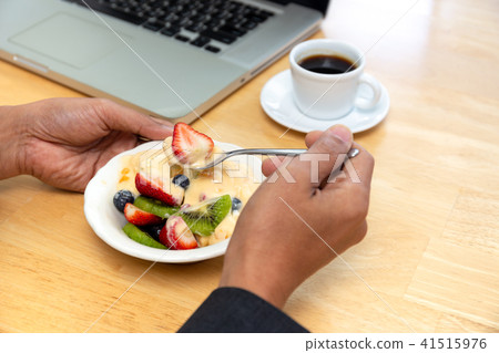 Businessman having fruits salad with yogurt Businessman having fruits salad with yogurt 41515976