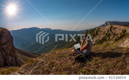 man with laptop on beauty mountains landscap 41516054