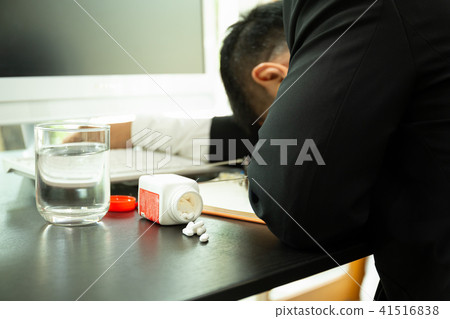 Pills spilling out with businessman fall sleep  41516838