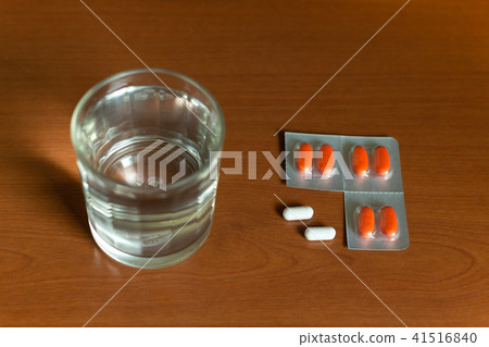 Glass of water and pills on wooden table 41516840
