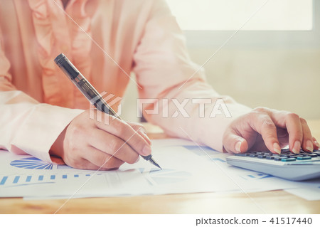 Asian Business woman using a calculator to count Asian Business woman using a calculator to count 41517440
