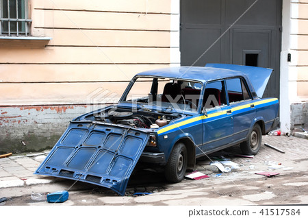 car destroyed by protesters during riot. Police car destroyed near police department, city center car destroyed by protesters during riot. Police car destroyed near police department, city center 41517584