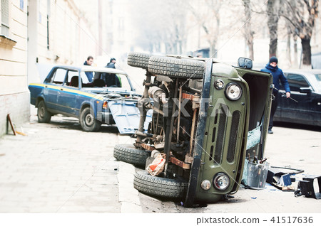 cars destroyed by protesters during riot. Two police cars destroyed near police department 41517636
