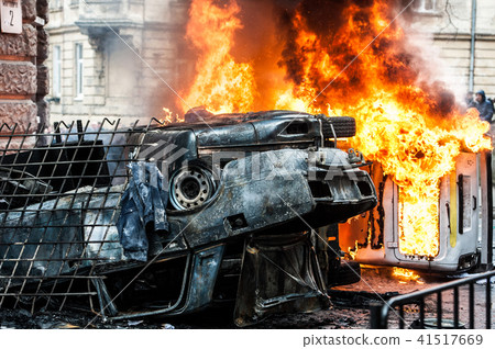 burning car. car destroyed and set on fire during the riots. city center 41517669