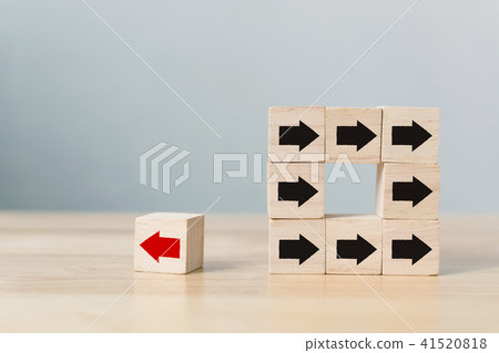 Wooden block with red arrow facing the opposite 41520818
