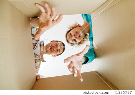 Image of man and woman peering into cardboard box 41525737