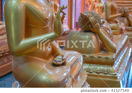 Donation coins lie on palm wax gilt figure monk. 41527549