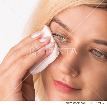 Woman Cleaning Face with white cotton pad. Woman Cleaning Face with white cotton pad. 41527937
