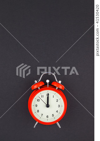 Red vintage alarm clock on dark background Red vintage alarm clock on dark background 41530420