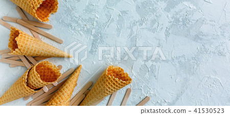 Wooden sticks and waffle cones for ice cream. Wooden sticks and waffle cones for ice cream. 41530523