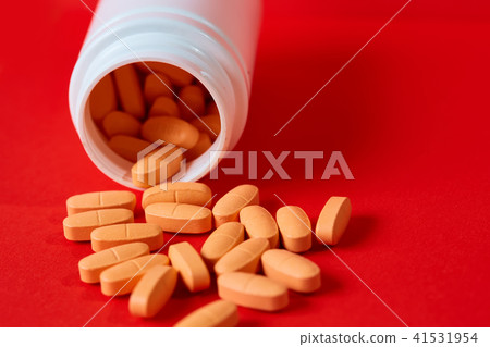 Pills spilling out of pill bottle on red. Top view with copy space. Pills spilling out of pill bottle on red. Top view with copy space. 41531954