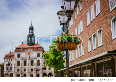 Vintage street light lantern with flowerbed. Historic town hall on the background in Lueneburg 41532578