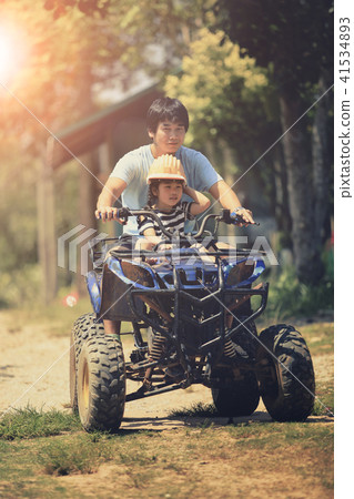 father and daughter riding on quad atv  41534893