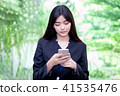 woman watching her photos on cellphone 41535476