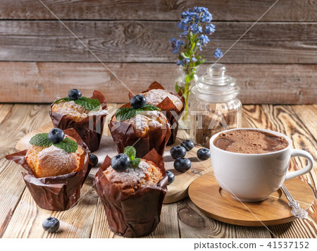 Muffins with blueberries and a cup hot chocolate 41537152
