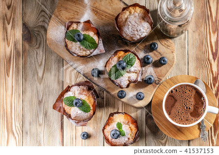 Muffins with blueberries and a cup hot chocolate 41537153