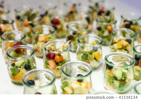 Closeup many dessert jar rowed up on buffet table with fresh fruits jelly and cream Closeup many dessert jar rowed up on buffet table with fresh fruits jelly and cream 41538134