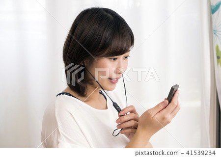 Woman listening to a digital audio player 41539234