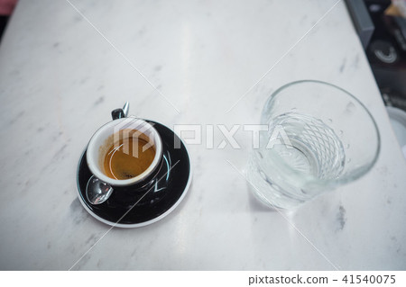 coffee mug and a glass of water on a table 41540075