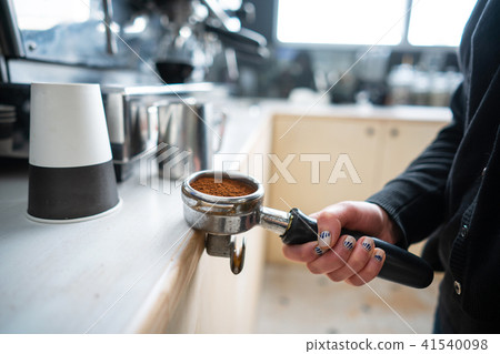 Barista holding portafilter with ground coffee Barista holding portafilter with ground coffee 41540098