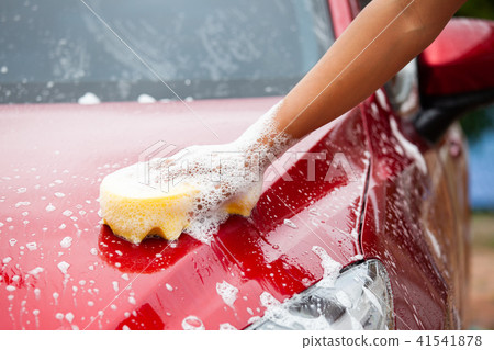 Man washing red car with sponge and soap Man washing red car with sponge and soap 41541878