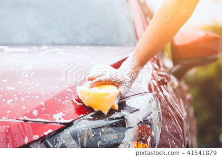 Man washing red car with sponge and soap Man washing red car with sponge and soap 41541879