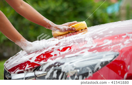 Man washing red car with sponge and soap Man washing red car with sponge and soap 41541880