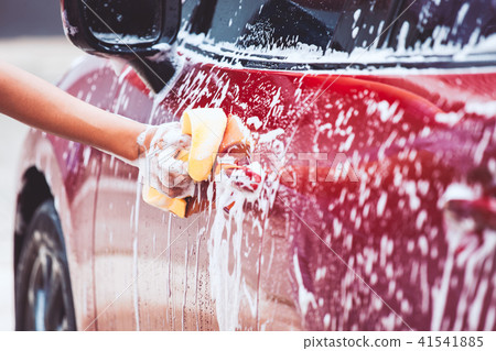 Man washing red car with sponge and soap Man washing red car with sponge and soap 41541885