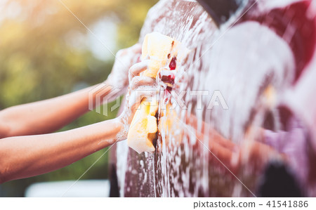 Man washing red car with sponge and soap Man washing red car with sponge and soap 41541886