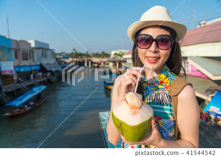 woman looking at camera and holding a coconut woman looking at camera and holding a coconut 41544542